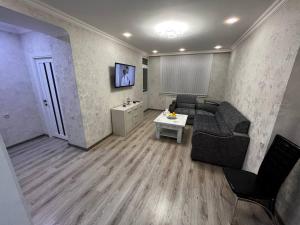 ein Wohnzimmer mit Sofa und Tisch in der Unterkunft Central Charm Guesthouse in Gjumri + 3 Fotos