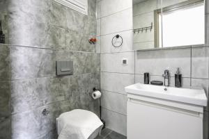 a bathroom with a sink and a toilet and a mirror at Just Dream Suites in Kaş