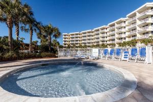 a large swimming pool with chairs and a building at Destin West Villa Gulfside V406 in Fort Walton Beach