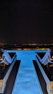 a view of a swimming pool at night at Sunset Hill Suites in Mikonos