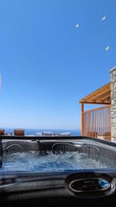 a hot tub on the back of a house at Sunset Hill Suites in Mýkonos City