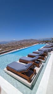 szereg leżaków przy basenie w obiekcie Sunset Hill Suites w mieście Mykonos