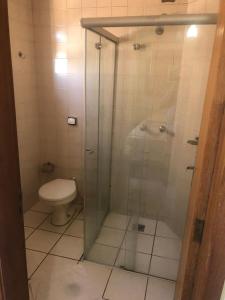 a bathroom with a glass shower with a toilet at Hotel Nações in Presidente Prudente