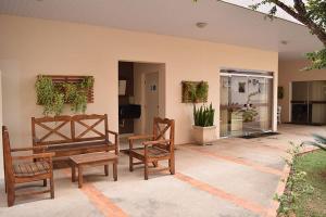 une terrasse avec deux bancs, une table et des chaises dans l'établissement Hotel Nações, à Presidente Prudente