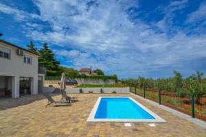 a swimming pool in the backyard of a house at Apartment Kaplja in Novigrad Istria