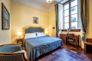 um quarto com uma cama, uma secretária e uma janela em Soggiorno Campos em Florença