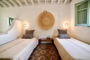dwa łóżka siedzące obok siebie w pokoju w obiekcie Alojamiento rural CASAPIÑA w mieście Conil de la Frontera