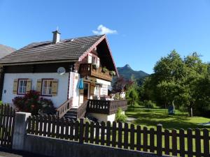 uma pequena casa com uma cerca em frente em Knusperhaus em Strobl