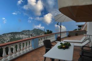 a balcony with a table and an umbrella at Villa Gesualda in Ischia