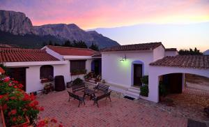 a house with a patio with mountains in the background at Agriturismo Guthiddai in Oliena