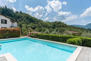una piscina con una montaña en el fondo en * Villa Ulivi - Private Pool with Panoramic Views, en Barga