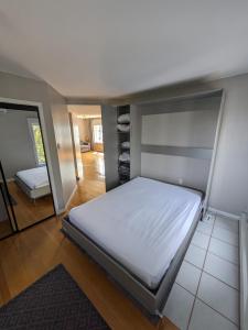 1 dormitorio con 1 cama grande y espejo en Le Cocon du Rivage, en Roberval