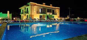 a swimming pool in front of a house at night at Sierra Hotel Tbilisi in Tbilisi City