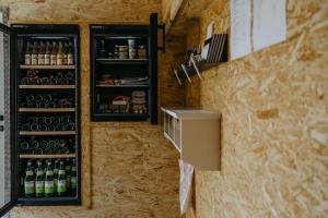 a bar with a refrigerator and bottles of beer at Studio 777 Apartments in Illmitz