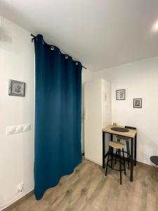 a blue curtain in a room with a table at Studio au calme. in Marseille