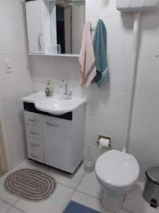 a white bathroom with a toilet and a sink at Apartamento London - Centro Nova Petrópolis in Nova Petrópolis