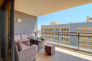 a balcony with a couch and a table on a building at Rooftop pool, 200m from sea, city center in Olhão
