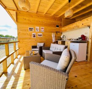une terrasse avec des chaises en osier et une cuisine dans une cabine dans l'établissement CozyHut Бунгало под Наем, à Tchernomorets