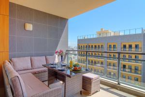 een woonkamer met een bank en een tafel op een balkon bij Rooftop pool, 200m from sea, city center in Olhão