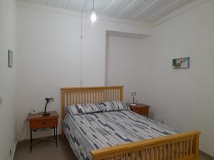 a bedroom with a wooden bed and two night stands at Rose Rooms in Faro