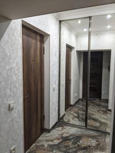 um corredor vazio com um espelho e uma porta em Movsisyan guest house em Guiumri