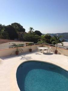 a large blue swimming pool on top of a house at Hermosa Casa Lomas del Marques Diamante in Acapulco
