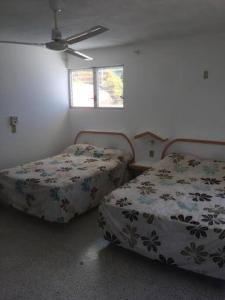 a bedroom with two beds and a window at Hermosa Casa Lomas del Marques Diamante in Acapulco