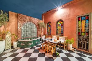 um pátio com uma mesa, cadeiras e vitrais. em Riad Appart Arwa em Marrakech