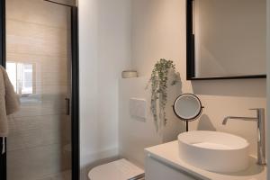 een witte badkamer met een wastafel en een douche bij Huys17 in Hasselt