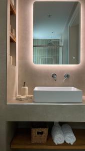 ein Badezimmer mit einem weißen Waschbecken und einem Spiegel in der Unterkunft Lagouvardos Beach House in Marathopoli