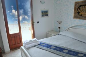 een slaapkamer met een bed en een deur met een raam bij Villa Gesualda in Ischia