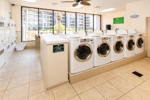 a laundry room with a row of washers and dryers at Renaissance 1009 in Myrtle Beach