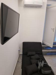Sofá negro en una habitación con TV de pantalla plana en Il Panorama en Vietri