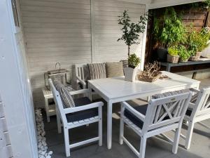 - une table et des chaises blanches sur la terrasse dans l'établissement Söl Hüs, à Tinnum