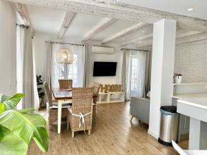 sala de estar con mesa, sillas y TV en Old Town Modern Flat, 4 Minutes From Beach - EaW Homes, en Marbella
