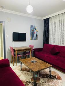 a living room with a red couch and a table at palmiye butik otel in Mezitli