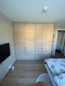 a bedroom with a large closet with a flat screen tv at Studio Leiligheit in Sogndal