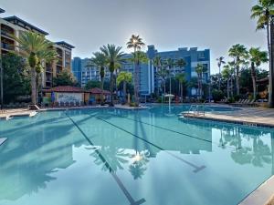 ein großer Pool mit Palmen und Gebäuden in der Unterkunft Vacation Villa At Orlando Resort in Orlando