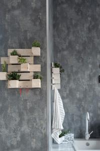 a bathroom with plants in wooden boxes on a wall at La corte in Sannicandro di Bari