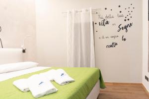 a bedroom with a bed with two towels on it at La corte in Sannicandro di Bari
