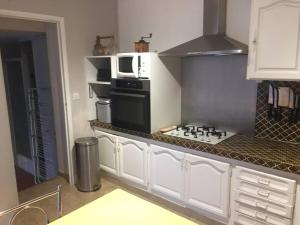 a kitchen with a microwave and a stove top oven at Villa plein pied, 2 eme ligne plage sable fin in Mauguio +5 photos