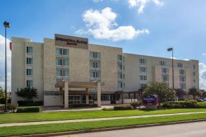 a large building with a sign on the front of it at SpringHill Suites by Marriott Houston Rosenberg in Rosenberg