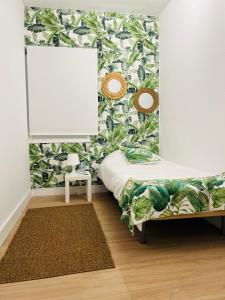 1 dormitorio con 1 cama con papel pintado tropical en Stadiumapartament, en Santa Cruz de Tenerife