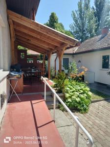 uma pérgola de madeira ao lado de uma casa em Balassa House em Siófok