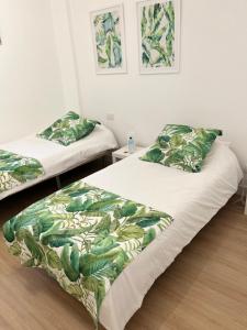 1 dormitorio con 2 camas con hojas verdes en Stadiumapartament, en Santa Cruz de Tenerife