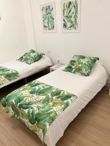 a bedroom with two beds with green leaves at Stadiumapartament in Santa Cruz de Tenerife