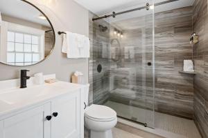 a bathroom with a toilet and a glass shower at Pelham on Main in West Dennis