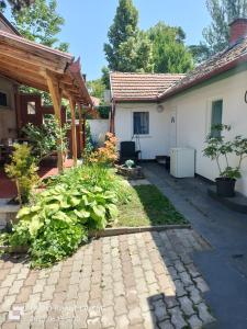 um quintal com uma casa e um passadiço de tijolos em Balassa House em Siófok