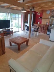 uma sala de estar com um sofá e uma mesa em Maison individuelle, La Miloune em Le Val