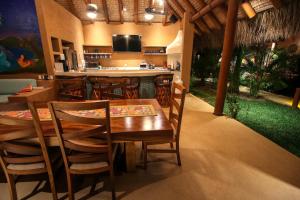 a restaurant with a table and chairs and a bar at Casita Linda, a luxury house near the beach! in Zihuatanejo